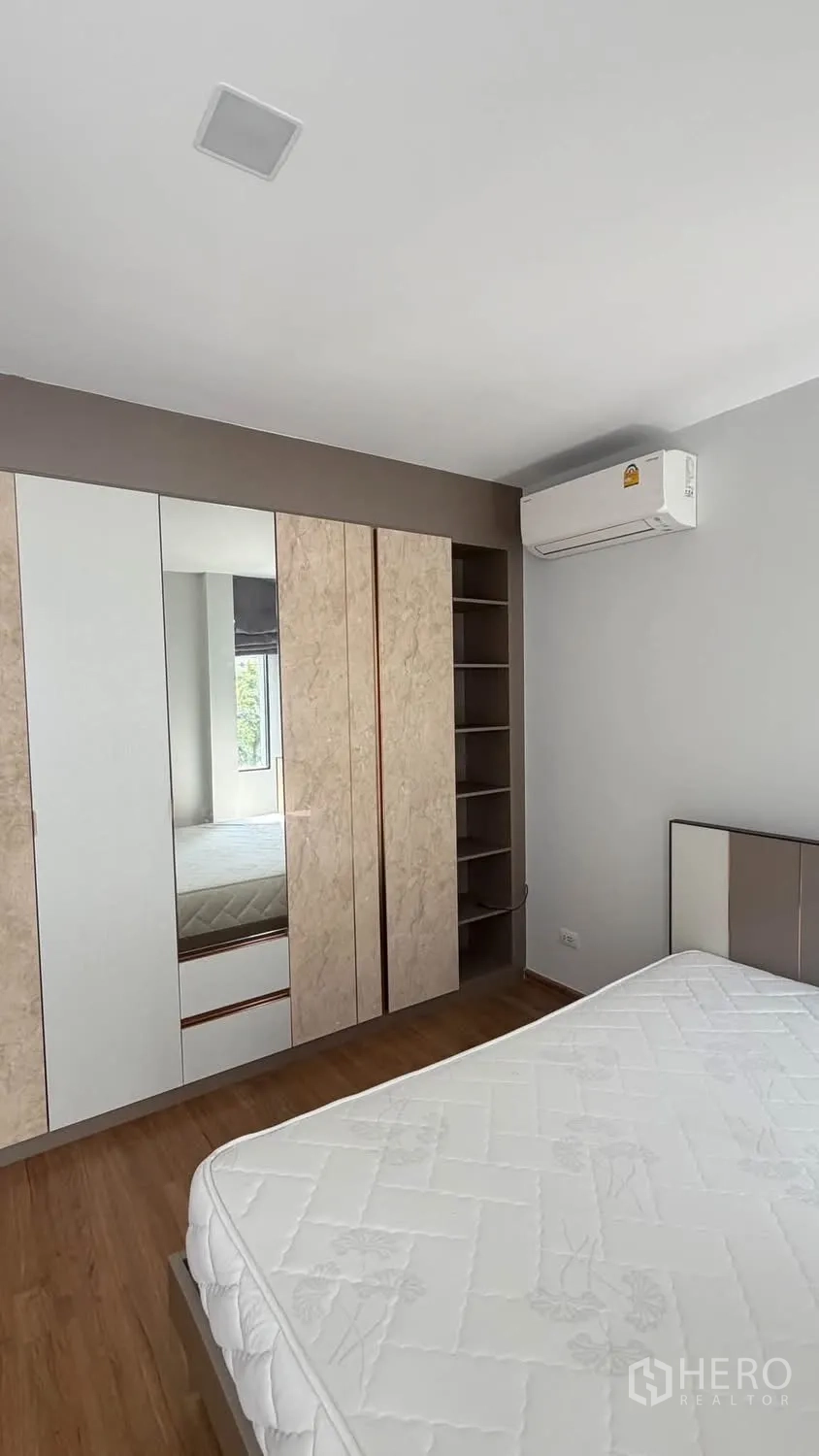 Townhouse for rent in Bang Phli, Samut Prakan - Bedroom featuring a large mirrored wardrobe, air conditioner, and shelving.
