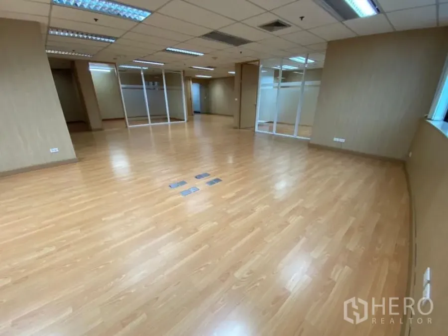 สำนักงาน ให้เช่าในWatthana, Bangkok - โซนทำงานแบบโอเพ่นสเปซ พื้นลามิเนต ไฟฟลูออเรสเซนต์ และผนังกระจกกั้นห้องประชุม