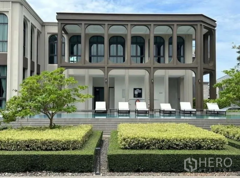 独立式住宅 出租在Lat Krabang, Bangkok - 社区会所，拱廊设计，池畔躺椅与修剪整齐的花园。