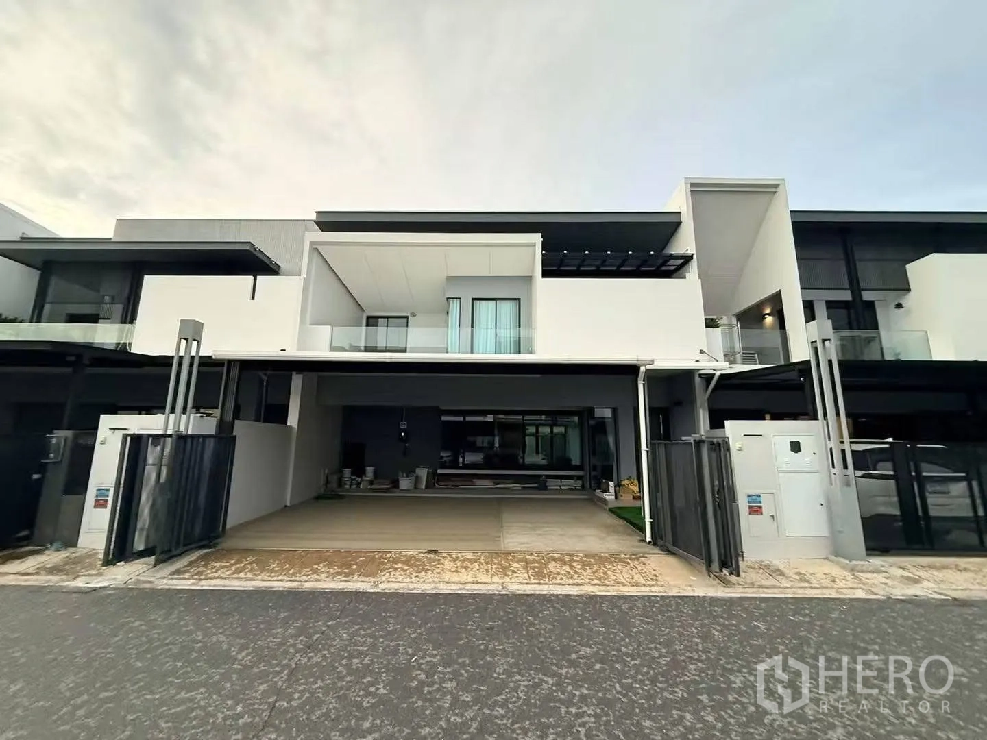 Townhouse for rent in Bang Phli, Samut Prakan - Modern townhouse facade with gated carport and balcony.