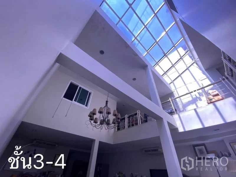 Shophouse for rent in Watthana, Bangkok - Double-height atrium with glass roof and chandelier bringing natural light.
