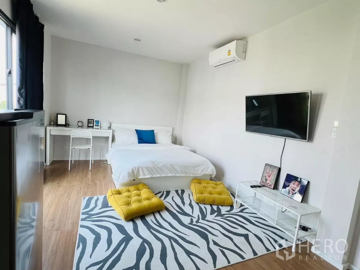 Detached House for rent in Saphan Sung, Bangkok - Master bedroom view with bed, TV and a work desk by the window.