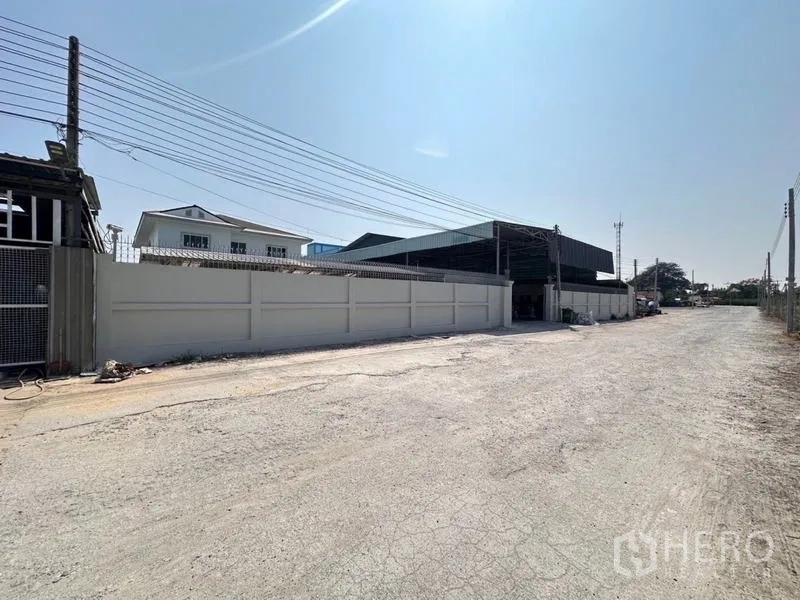 货栈 出售在Bang Phli, Samut Prakan - 通往仓库入口的外部道路视角，高围墙与宽敞通行车道。
