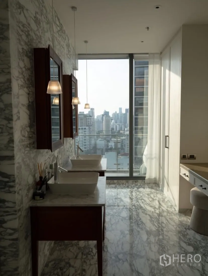 Condominium for rent or sale in Watthana, Bangkok - Marble-clad bathroom with double vanity and floor-to-ceiling window.