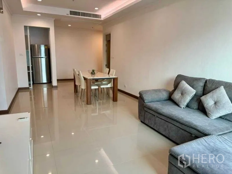 公寓 出售在Ratchathewi, Bangkok - 宽敞客厅，转角沙发、餐桌，与厨房相连。