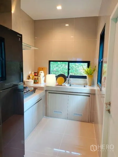 บ้าน ให้เช่าในBang Phli, Samut Prakan - ครัวแยก เคาน์เตอร์ ซิงก์ริมหน้าต่าง เตาและตู้เย็นสีดำ