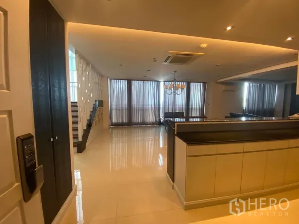公寓 出租在Bang Kapi, Bangkok - 开放式客餐厅，吊灯、吧台与落地窗相连。