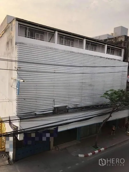Shophouse for rent in Phra Khanong, Bangkok - Street-facing multi-storey shophouse with corrugated metal facade and upper row of windows.