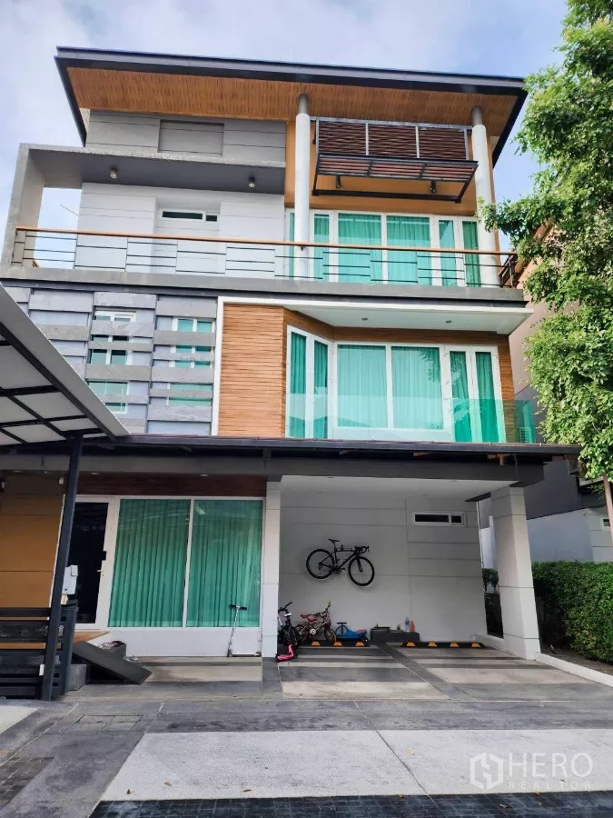 Detached House for rent or sale in Chatuchak, Bangkok - Three-storey modern detached house facade with covered parking and large glass windows in Chatuchak.