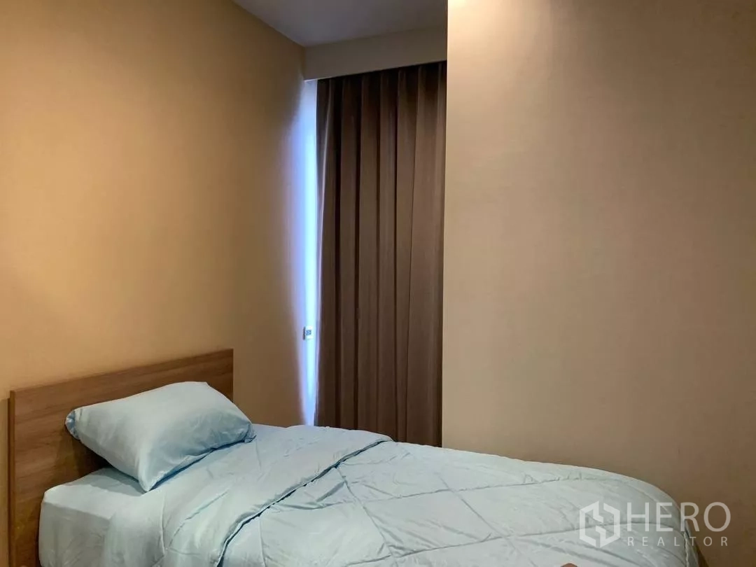 Condominium for rent or sale in Watthana, Bangkok - Second bedroom with single bed and blackout curtains for privacy.