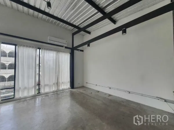 Retail Space for rent in Sathon, Bangkok - Minimalist retail room with track lighting, black steel beams, polished concrete floor, and sheer floor-to-ceiling curtains.