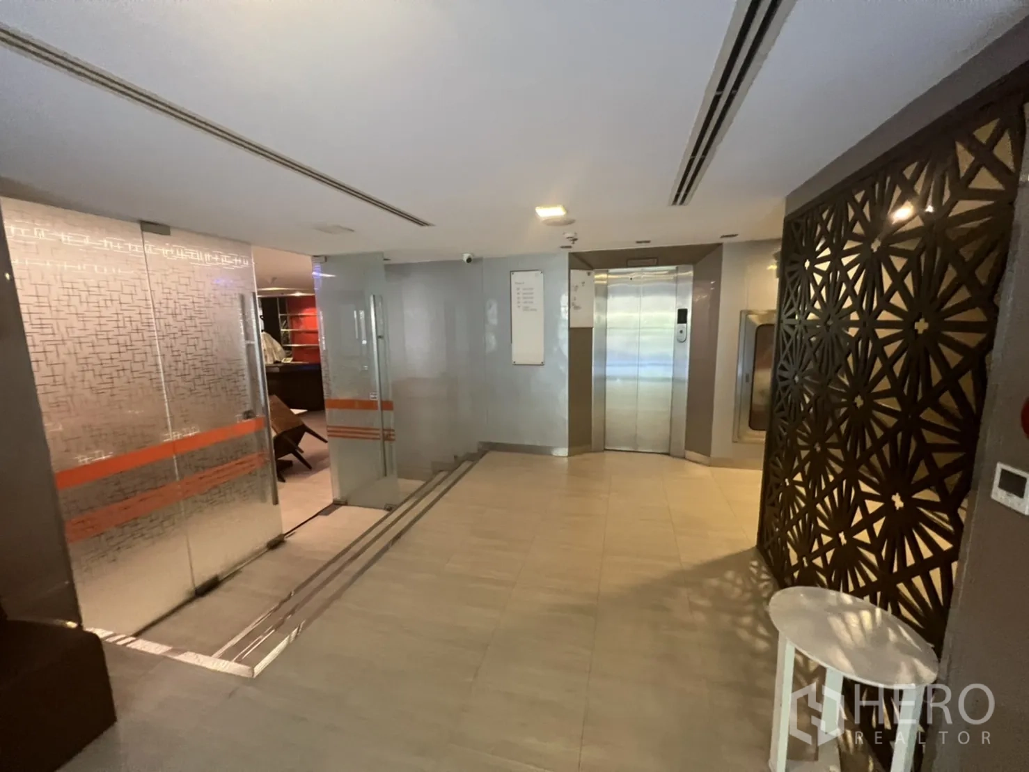 零售空间 出租在Khlong Toei, Bangkok - 大堂区，玻璃门、电梯与几何花纹隔屏。