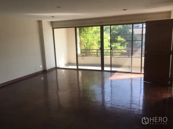 带办公室的家 出售在Watthana, Bangkok - 宽敞客厅，落地推拉门通往阳台，绿景采光充足。