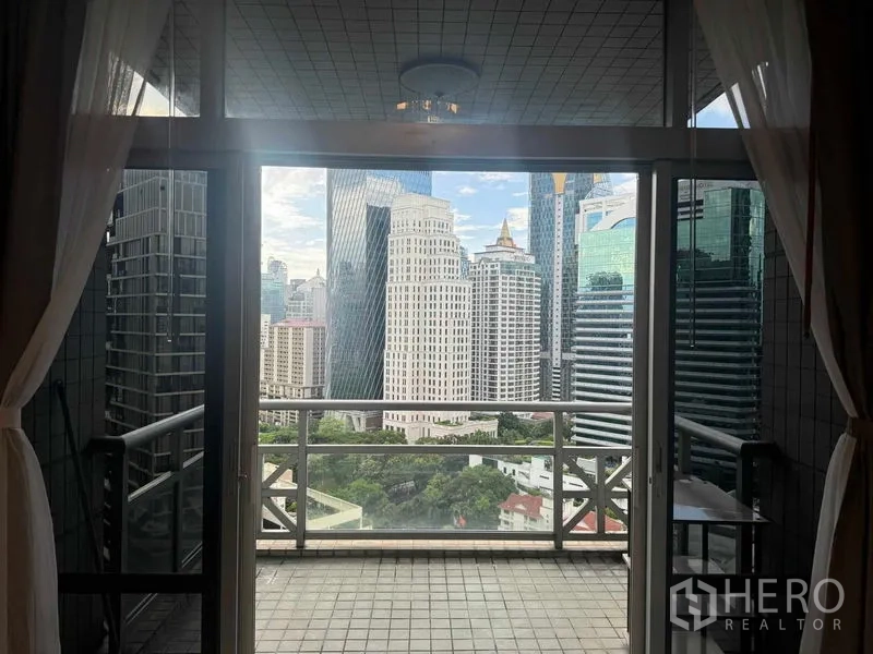 公寓 出租在Pathum Wan, Bangkok - 阳台通过落地玻璃俯瞰曼谷天际线与绿意景观。