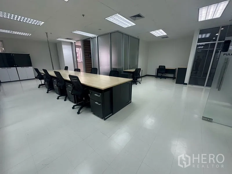 สำนักงาน ให้เช่า - พื้นที่สำนักงานกว้าง โต๊ะไม้ยาว ตู้เก็บของ และไฟฝ้าตาราง