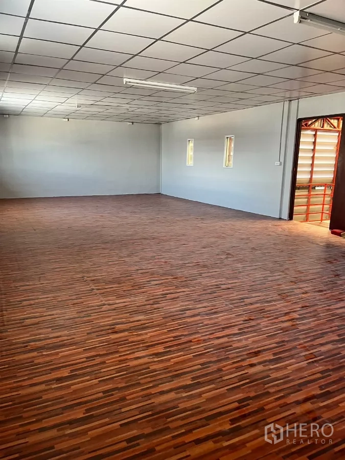 Warehouse for rent in Lat Lum Kaeo, Pathum Thani - Upstairs office room with drop ceiling and wood-pattern vinyl flooring.