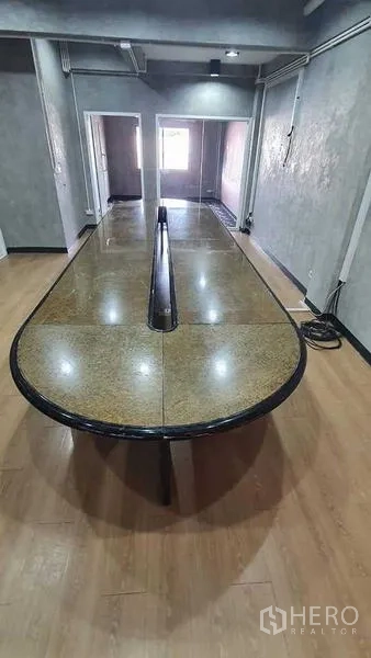 办公空间 出租或出售在Bueng Kum, Bangkok - 会议室配长条石面会议桌，木地板与混凝土质感墙面。
