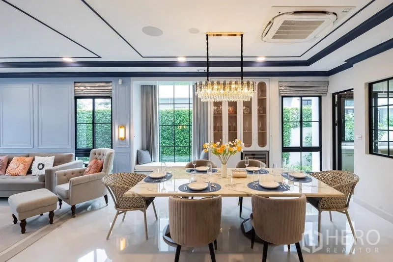 Detached House for sale in Saphan Sung, Bangkok - Dining room with marble table, crystal chandelier and garden outlook.