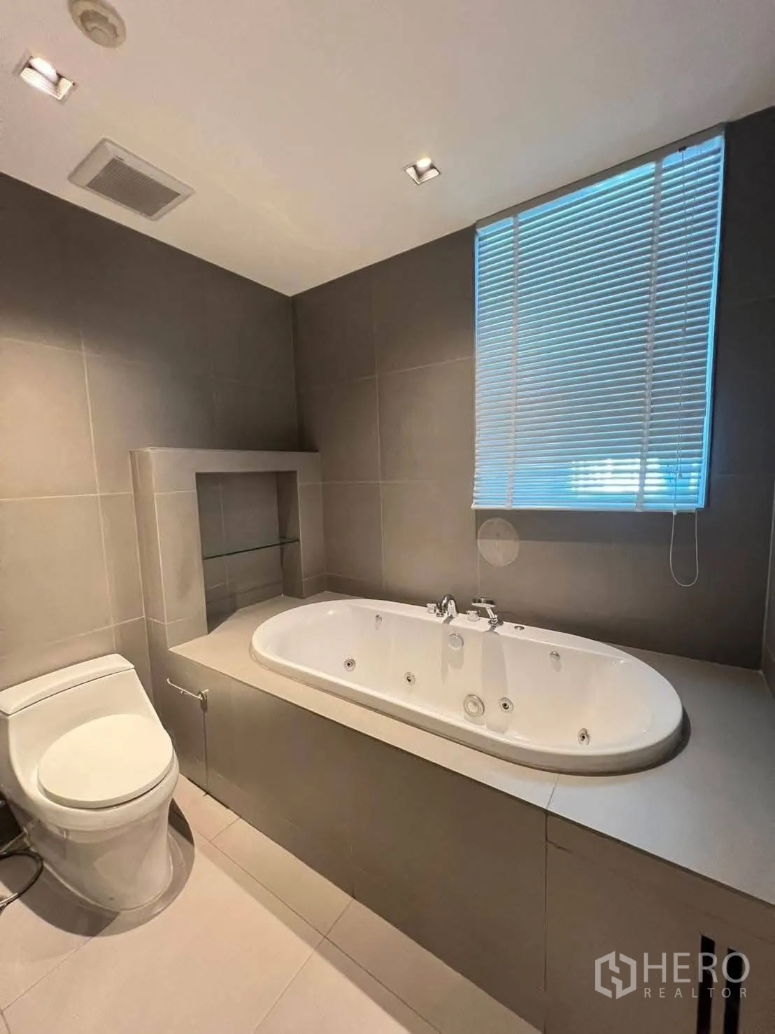 公寓 for rent in Pathum Wan, Bangkok - 浴室设有带喷嘴的按摩浴缸，旁有百叶窗。