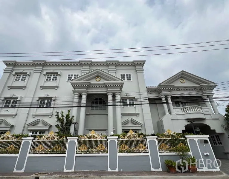 Detached House for rent in Bang Phli, Samut Prakan - Street view of a grand neoclassical facade with ornate fence and columns.