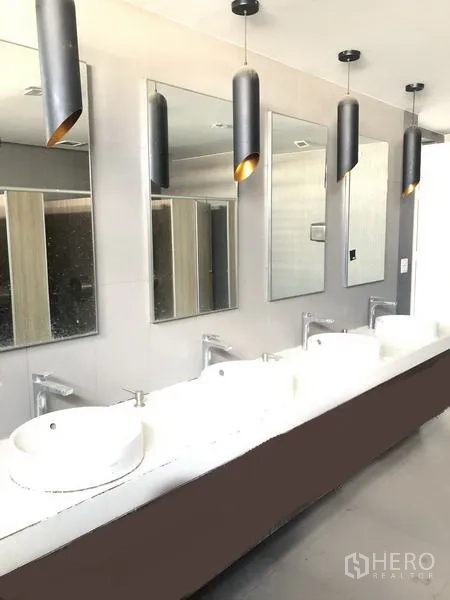 Office Space for rent in Suan Luang, Bangkok - Modern restroom with multiple vessel sinks, mirrors, and pendant lighting in a commercial building.