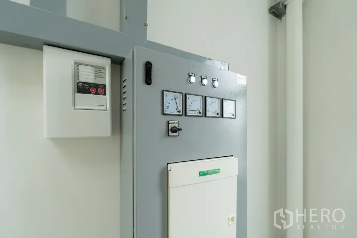 Factory for rent in Khlong Luang, Pathum Thani - Electrical control panel with gauges mounted on a white wall.