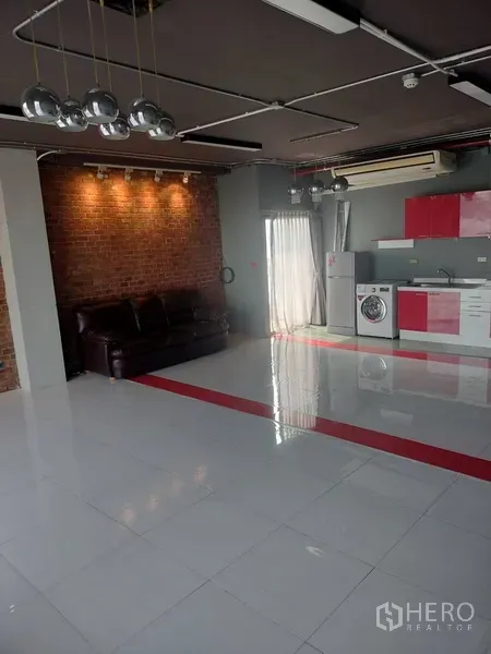 办公空间 出租在Khlong Toei, Bangkok - Loft风工作区，外露管线照明、红砖特色墙、沙发与明亮白色地砖。