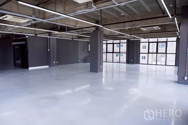 办公空间 出租 - 宽敞工作区，外露管线、分体空调与整面玻璃窗。