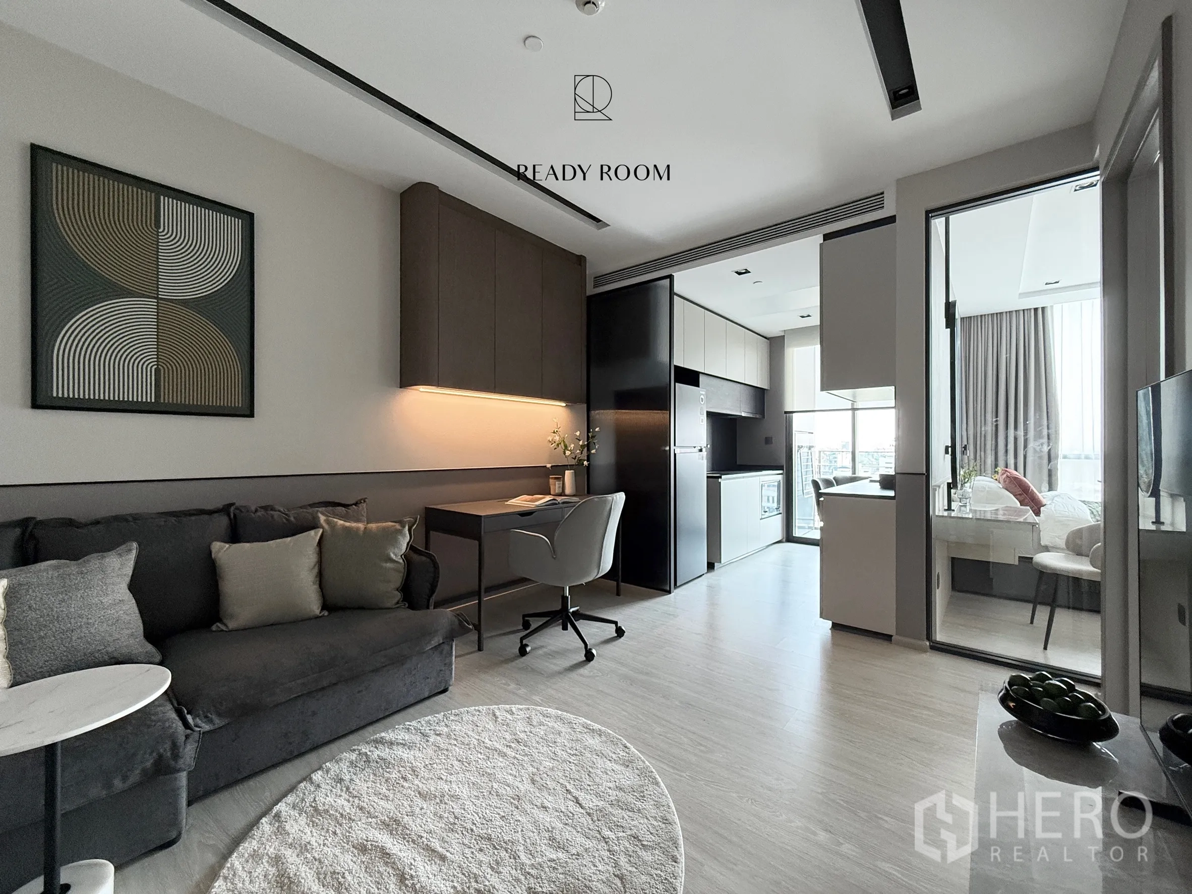 คอนโด for rent in Khlong Toei, Bangkok - ห้องนั่งเล่นแบบเปิดโล่งพร้อมโซฟา โต๊ะทำงาน ครัว และประตูกระจกสู่ห้องนอน.