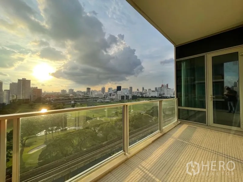 คอนโด ให้เช่าหรือขายในPathum Wan, Bangkok - ระเบียงกว้างพร้อมราวกระจก เห็นวิวพระอาทิตย์ตก สนามกอล์ฟ และเส้นขอบฟ้าเมือง