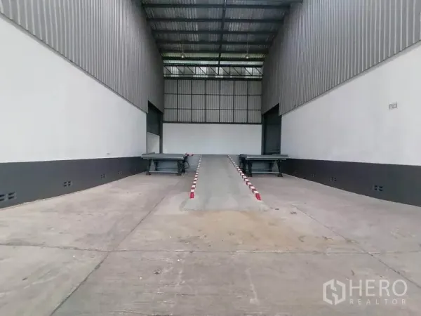 Warehouse for rent in Lat Krabang, Bangkok - Covered loading bay featuring a central truck ramp and dock levelers at roll-up doors.