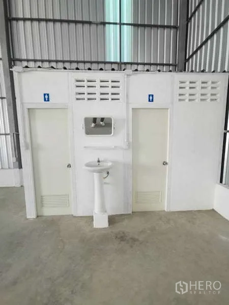 Warehouse for rent in Prawet, Bangkok - Male and female restrooms with a sink block inside the warehouse.