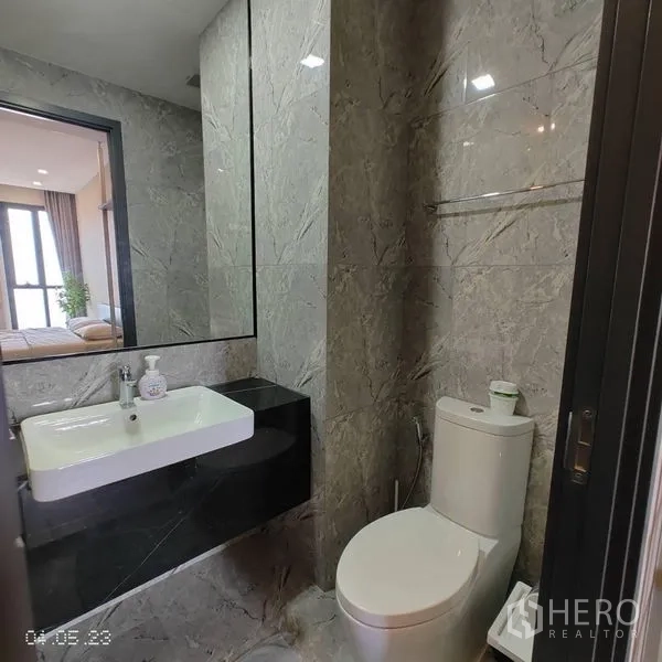 คอนโด ให้เช่าในWatthana, Bangkok - ห้องน้ำสมัยใหม่ ผนังลายหินอ่อน กระจกบานใหญ่ อ่างล้างหน้า และโถสุขภัณฑ์