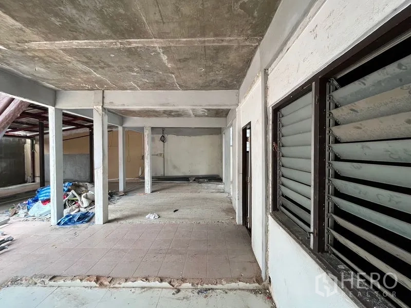 Retail Space for rent in Watthana, Bangkok - Raw hall with exposed concrete ceiling, column grid and louvered window panels.