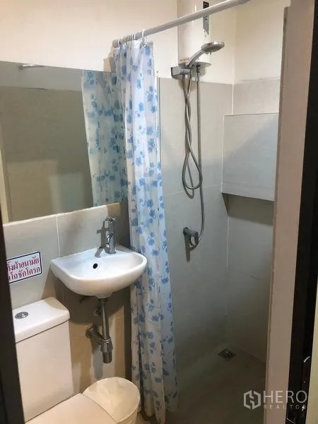 Retail Space for rent in Khlong Toei, Bangkok - Compact bathroom with shower area, curtain, sink and toilet.