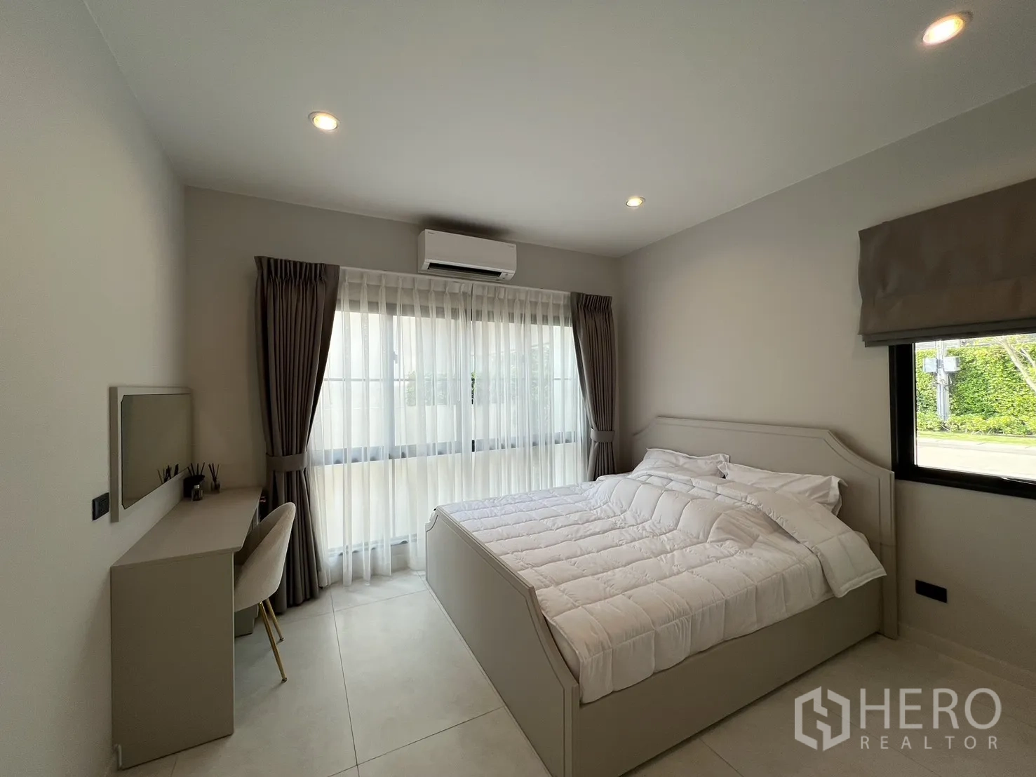 Detached House for rent in Bang Phli, Samut Prakan - Guest bedroom with desk, air conditioner and two windows.