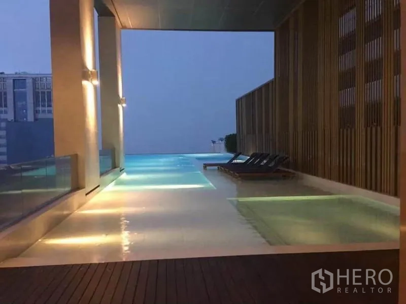公寓 出租在Watthana, Bangkok - 屋顶无边泳池，配躺椅与天际线景色。