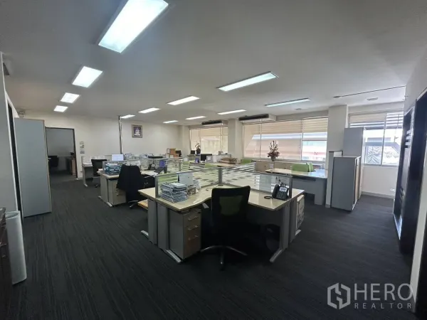 Office Space for rent - Open-plan office floor with multiple workstations, carpet flooring and large windows for natural light.