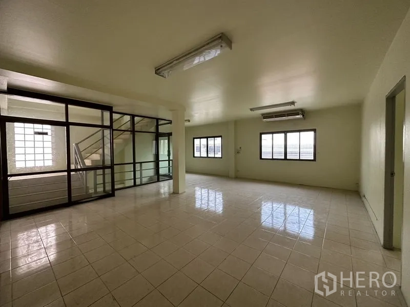 Factory for rent in Bang Bua Thong, Nonthaburi - Bright office area with glass partitions, windows, and stair access.