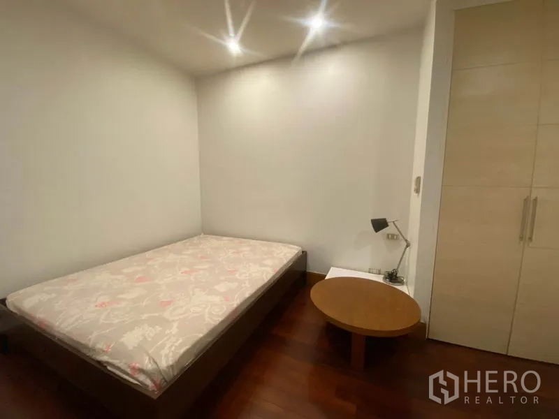 Condominium for rent in Sathon, Bangkok - Second bedroom with bed, wardrobe, bedside table, and warm lighting.