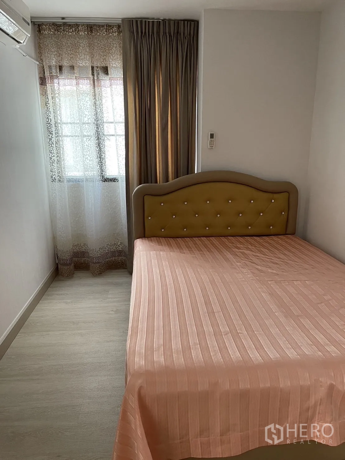 Condominium for rent or sale in Watthana, Bangkok - Cozy second bedroom with upholstered headboard and window with sheer and blackout curtains.