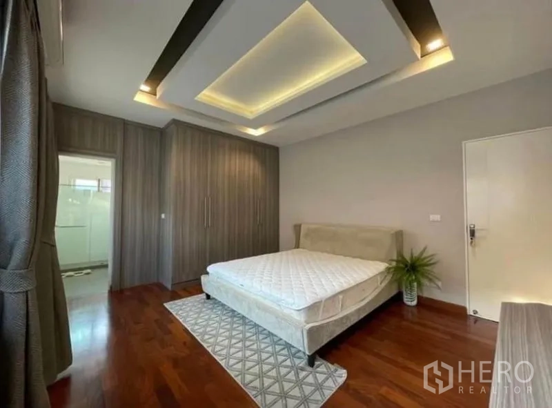 Detached House for rent or sale in Bang Phli, Samut Prakan - Bedroom with ensuite access, floor-to-ceiling wardrobes, area rug and full-length curtains.