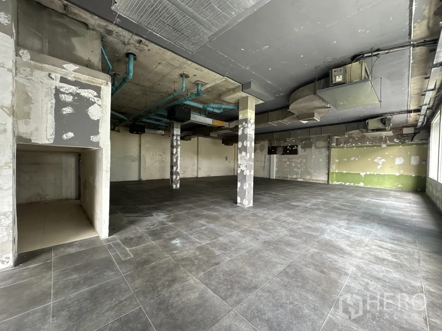 พื้นที่ขายของ for rent in Watthana, Bangkok - พื้นที่กระเบื้องกว้างมีผนังกั้นบางส่วนและช่องลมบนฝ้า.