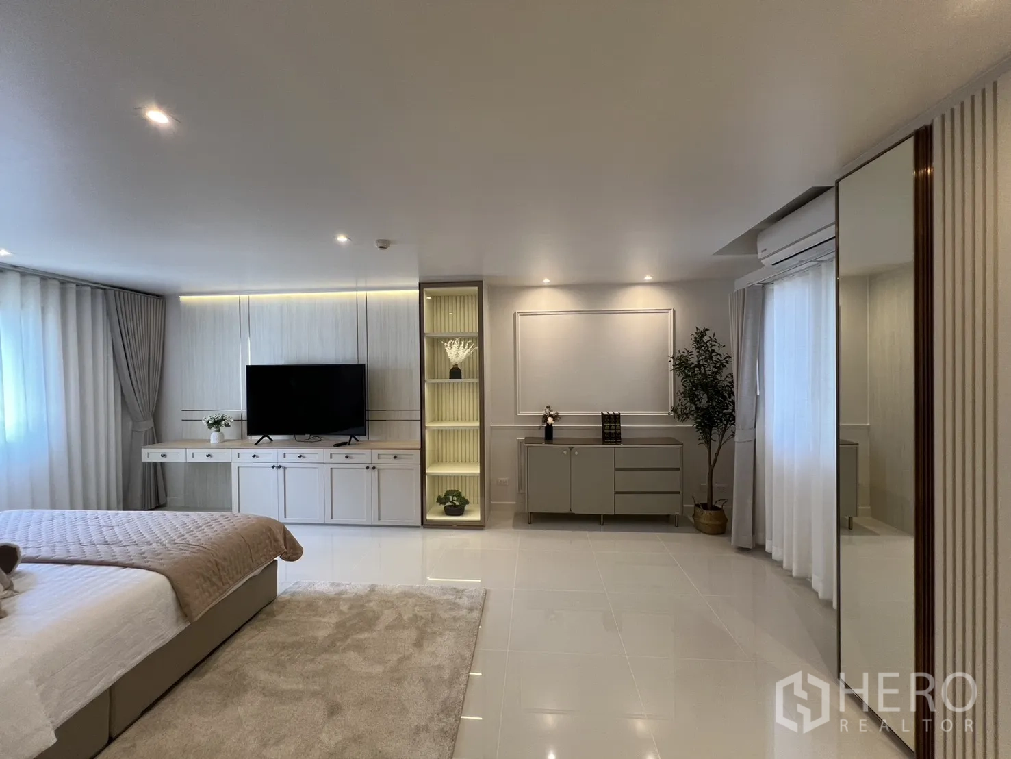 Condominium for rent in Yan Nawa, Bangkok - Master suite angle featuring built-in shelves with lighting and long TV console.