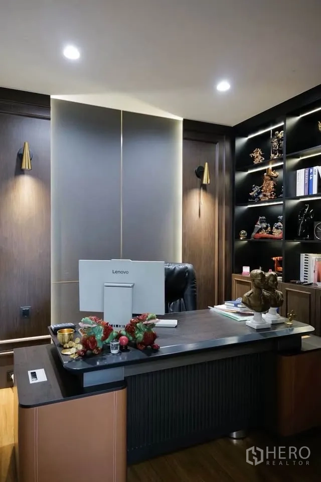 บ้านเดี่ยว for sale in Bang Phli, Samut Prakan - มุมใกล้ของห้องทำงานพร้อมชั้นโชว์มีไฟและคอมพิวเตอร์บนโต๊ะ.