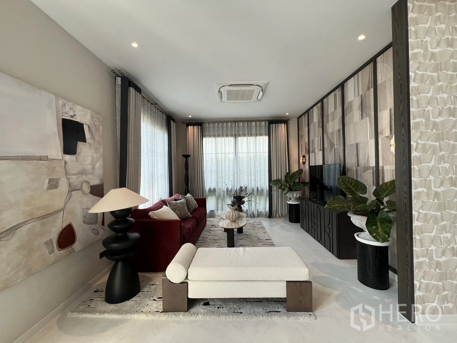 独栋房屋 for rent in Bang Phli, Samut Prakan - 明亮客厅，大幅艺术画、长凳与落地窗帘。