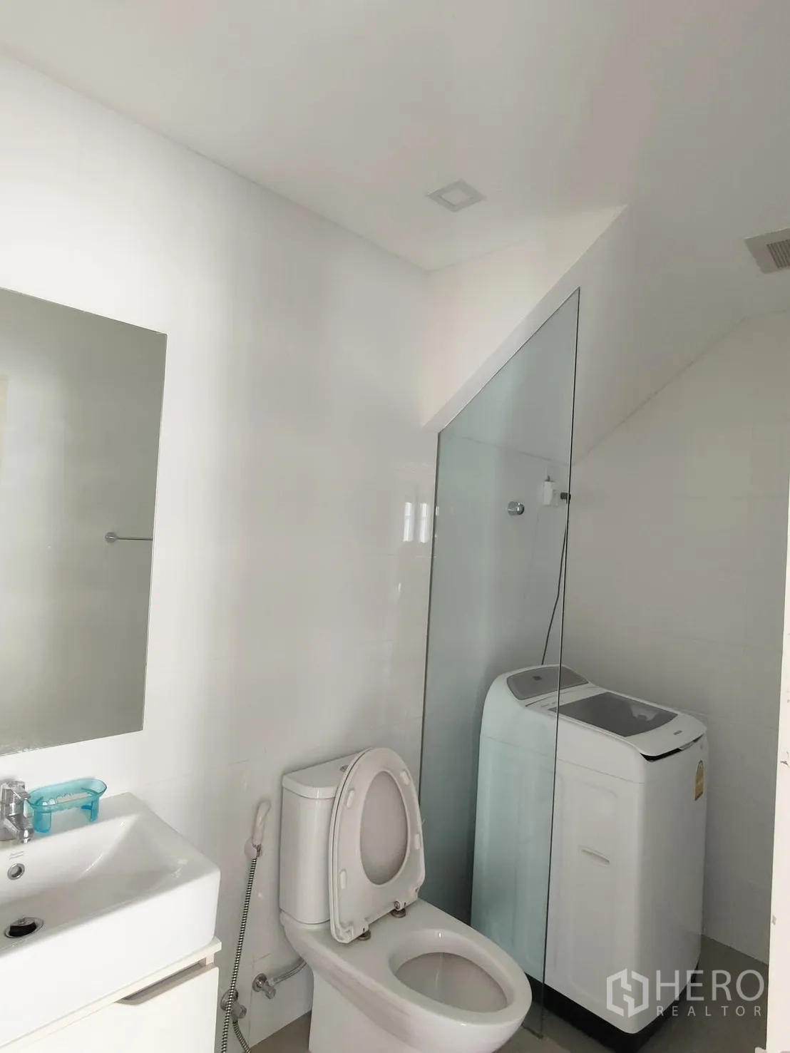 ทาวน์เฮาส์ for rent in Saphan Sung, Bangkok - ห้องน้ำสว่างพร้อมอ่างล้างหน้า โถสุขภัณฑ์ ฉากกั้นอาบน้ำกระจก และเครื่องซักผ้าแบบฝาบน