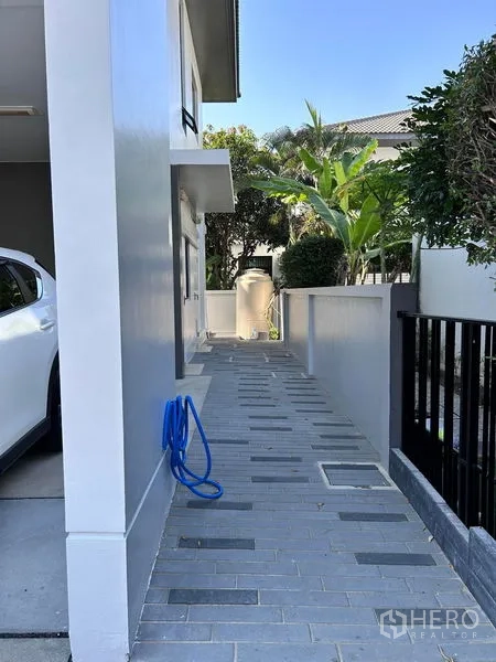 บ้าน ให้เช่าหรือขายในPrawet, Bangkok - ทางเดินข้างบ้านปูแผ่นทางเท้า มีต้นไม้และถังเก็บน้ำ