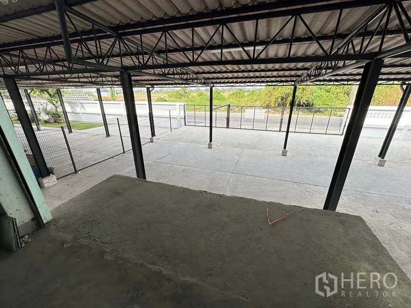Office Space for rent in Bang Sao Thong, Samut Prakan - Covered loading bay and wide concrete forecourt behind a secure metal fence.