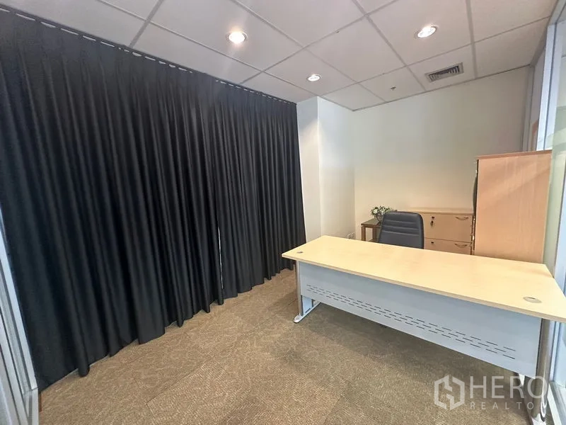 Office Space for rent in Bang Rak, Bangkok - Manager’s room with desk, storage cabinets and dark curtains.